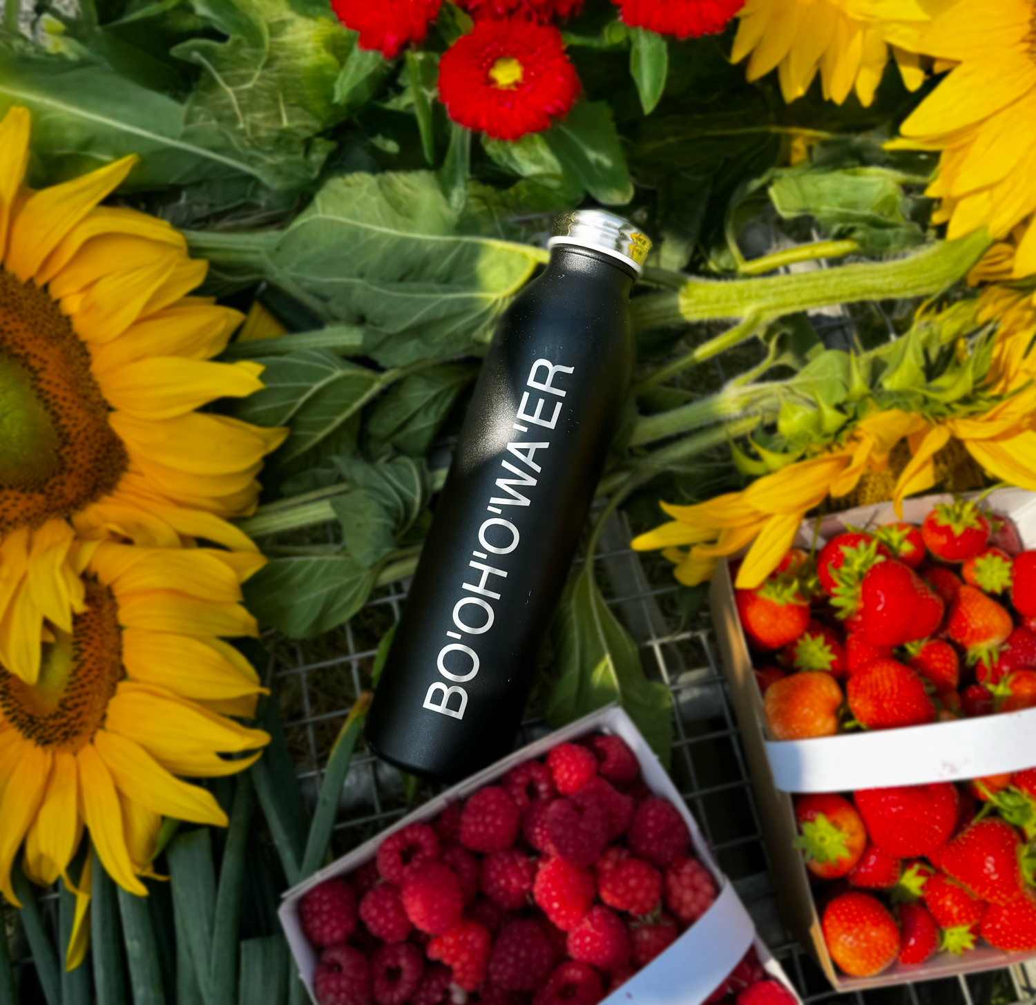 Black bottle with fruit and flowers